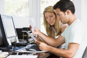 Financial stress and paperwork confusion at a chaotic home office.