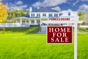 Foreclosure home for sale sign in front of a house, representing bankruptcy and foreclosure services in Long Island.