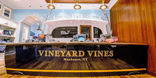 Vineyard Vines storefront in Manhasset, NY with colorful merchandise displayed inside.