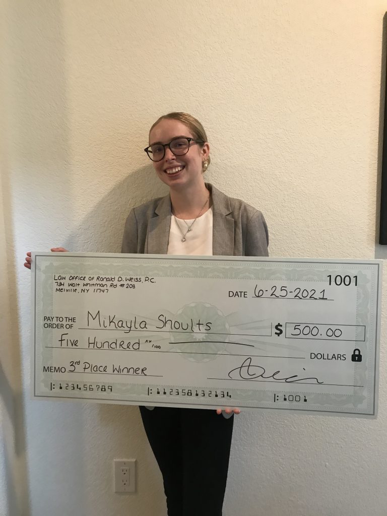 A person holds a large ceremonial check for $500.00 made out to Mikayla Shoults, awarded by the Law Office of Ronald D. Weiss, P.C. on June 25, 2021, for winning 3rd place in a competition.
