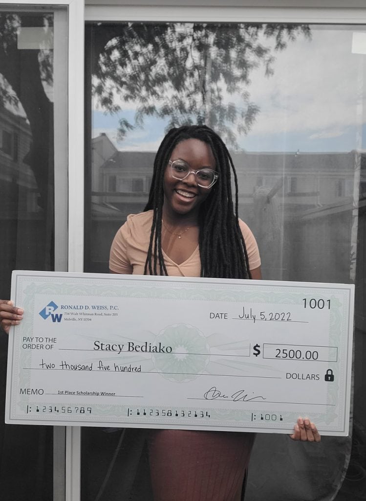 Person holding a large ceremonial check made out to Stacy Bediako for $2,500.00, dated July 5, 2022, from Ronald D. Weiss, P.C., with the memo '1st Place Scholarship Winner